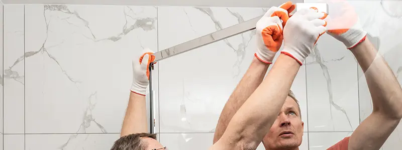 2 professionals installing glass shower door